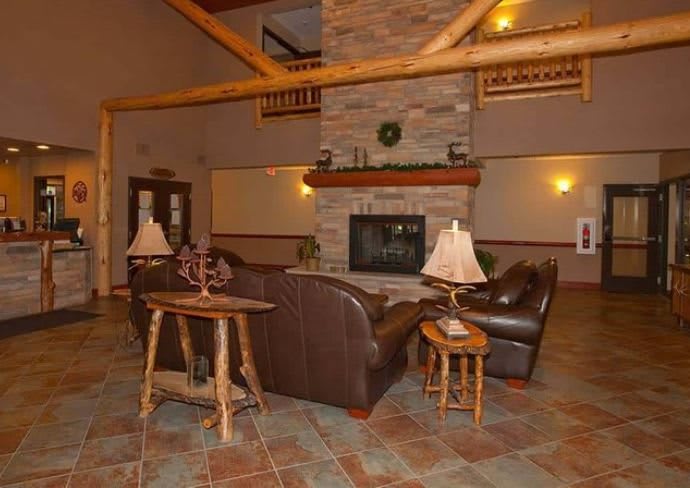A cozy lobby with a rustic fireplace and comfortable seating area.
