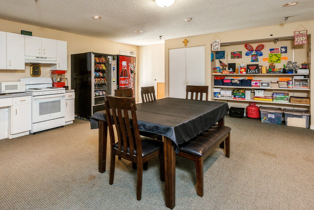 A kitchen and dining area featuring a table with chairs, appliances, and organized shelves.