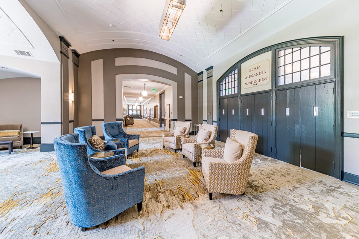 A spacious and elegantly designed lobby with comfortable armchairs and chandeliers.