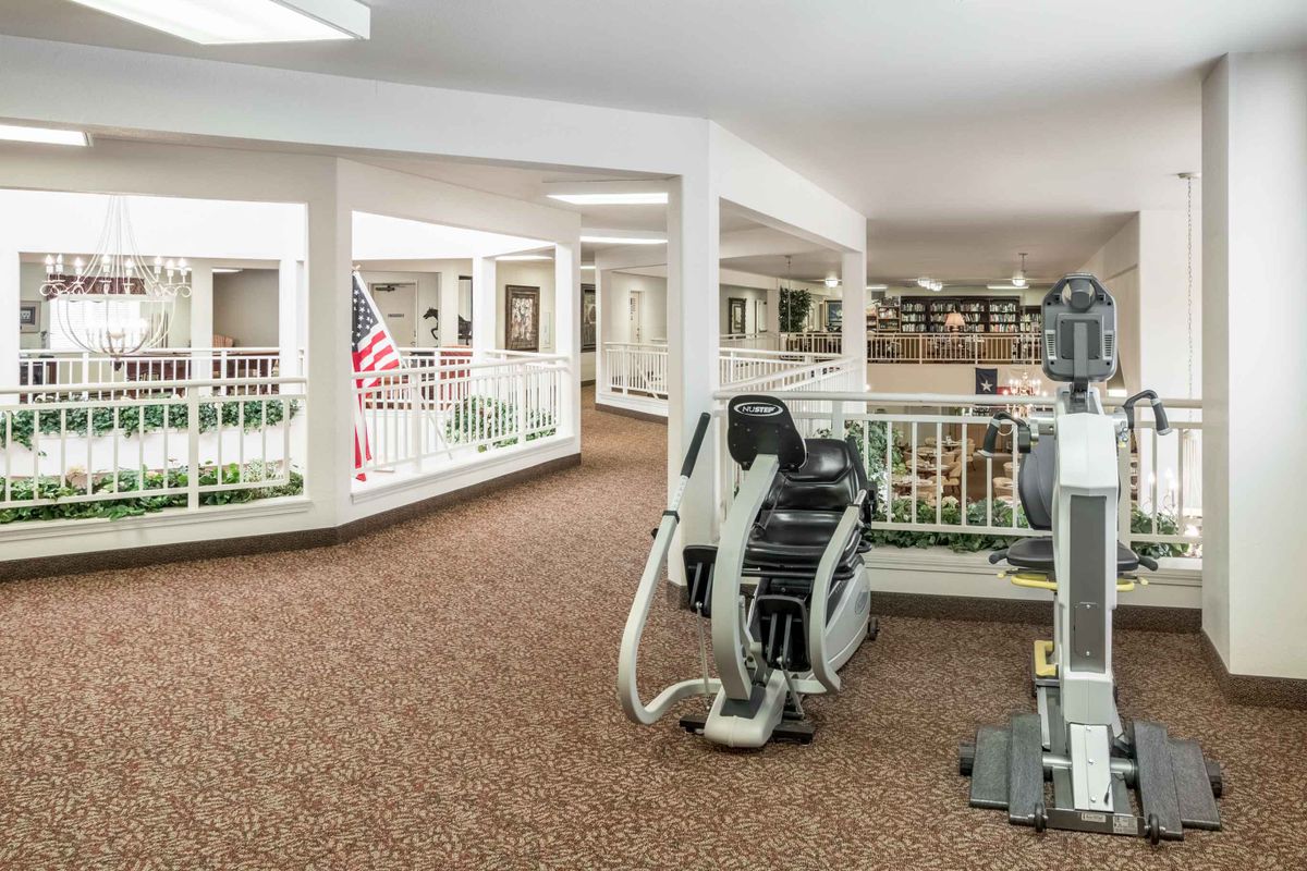 An indoor gym area featuring exercise machines on a carpeted floor.