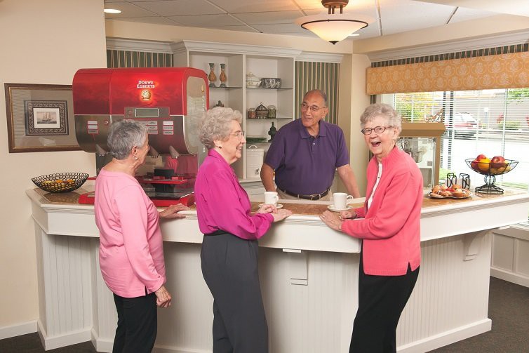 A group of seniors enjoying a conversation at a cafe counter.