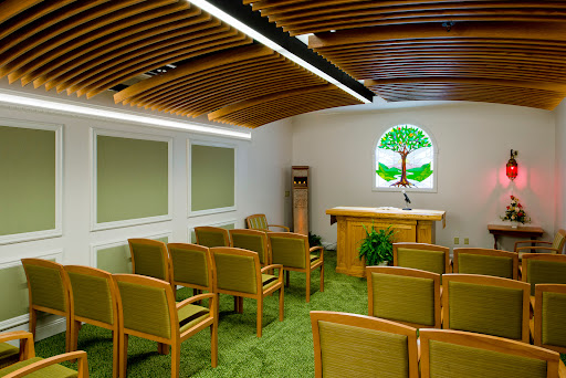 A serene interior space designed for gatherings, featuring wooden accents and a calming green aesthetic.