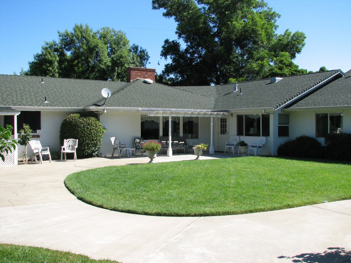 A single-story house with a well-maintained lawn and a circular driveway.