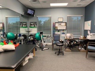 A physical therapy room equipped with exercise machines and therapy tools.