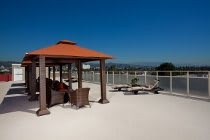A sunny rooftop with a gazebo and outdoor furniture for relaxation.