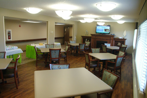 A spacious and well-lit common area featuring tables and chairs, suitable for dining or social gatherings.