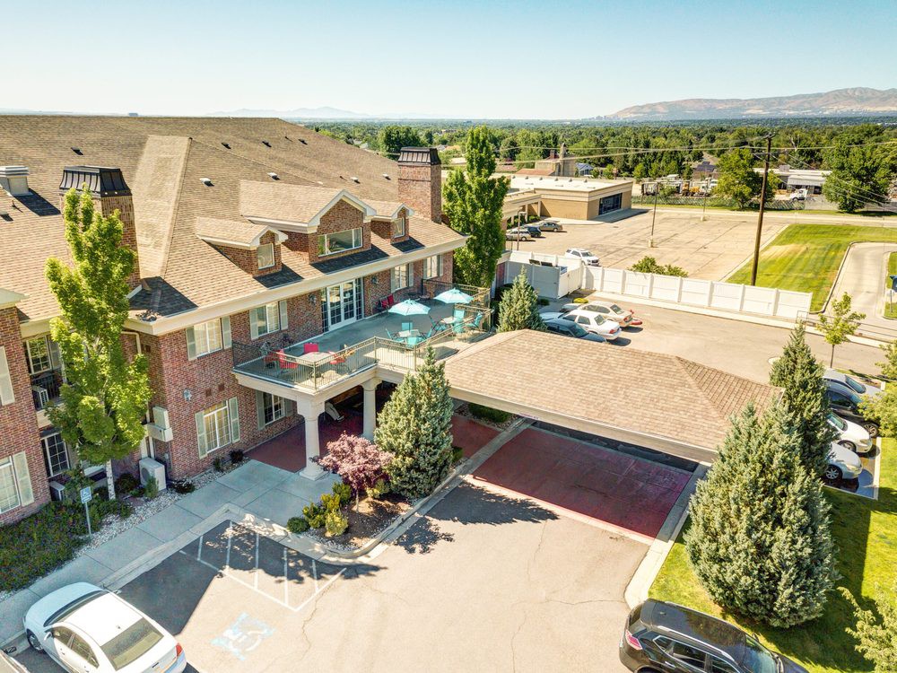 Aerial view of a large residential mansion with a spacious driveway and landscaped backyard.