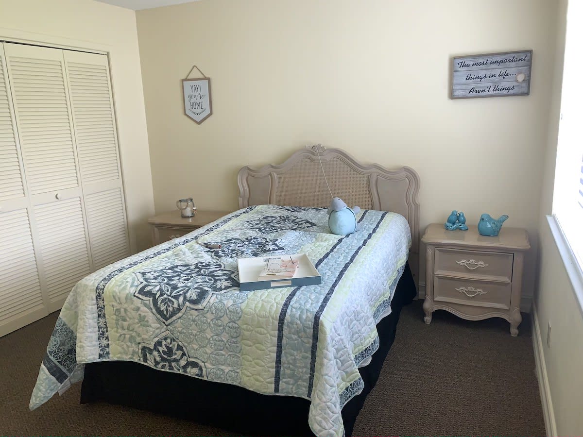 A cozy bedroom with a neatly made bed, nightstands, and decorative touches.