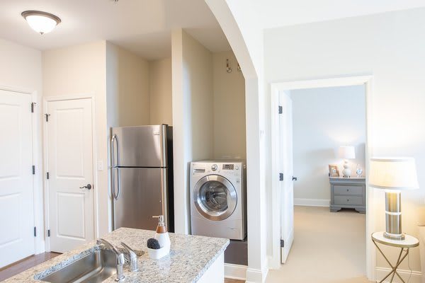 Modern kitchen with stainless steel appliances and in-unit laundry.
