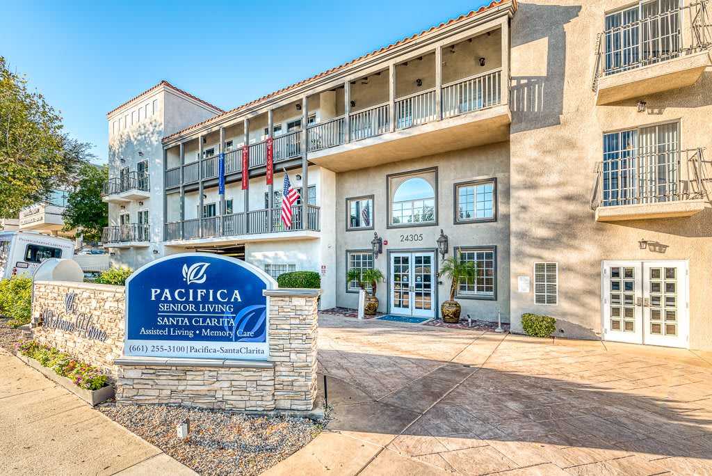 The exterior view of a residential building with visible signage and flags at the entrance.