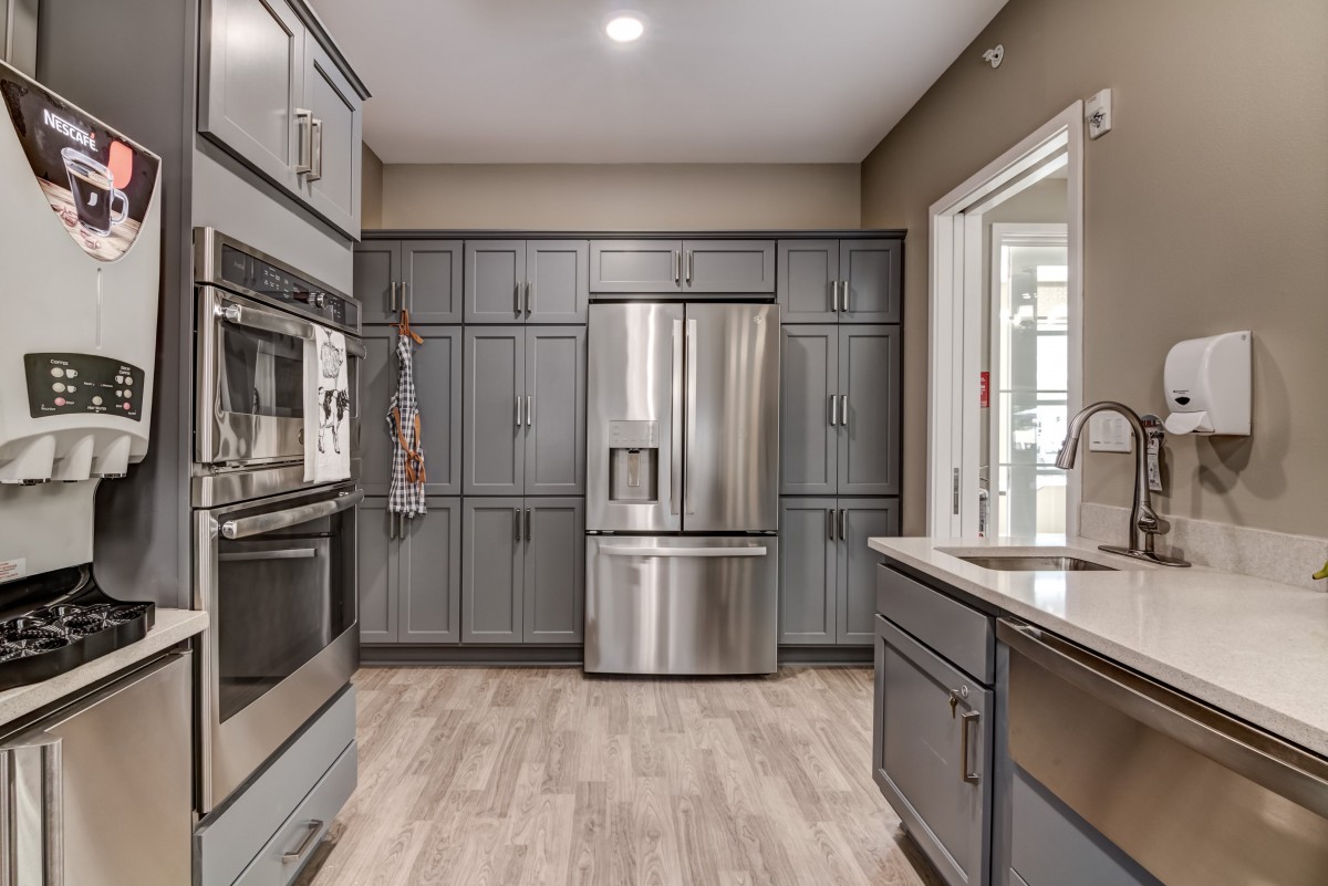 A modern kitchen featuring sleek gray cabinetry and stainless steel appliances.