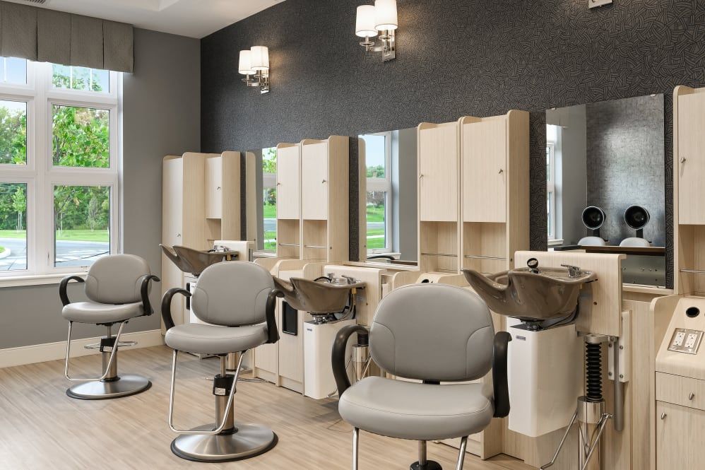 A modern hair salon interior with chairs, mirrors, and wash stations.