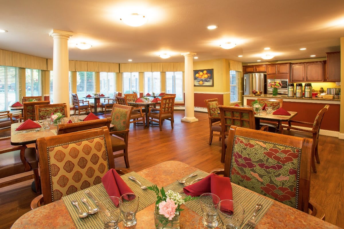 A cozy dining room with elegant decor, featuring neatly arranged tables and chairs.