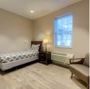A minimalist bedroom with a single bed and a cozy chair.