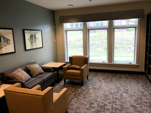 A cozy lounge area featuring comfortable seating and natural light streaming through large windows.
