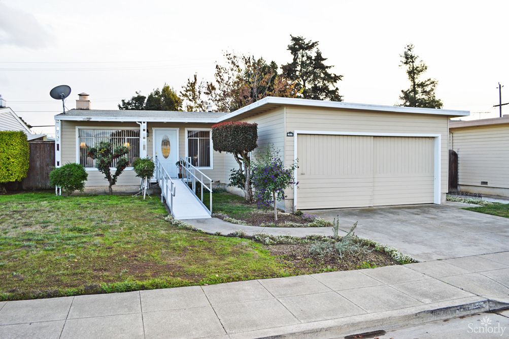 A suburban house with a ramp leading to the front door and a two-car garage.
