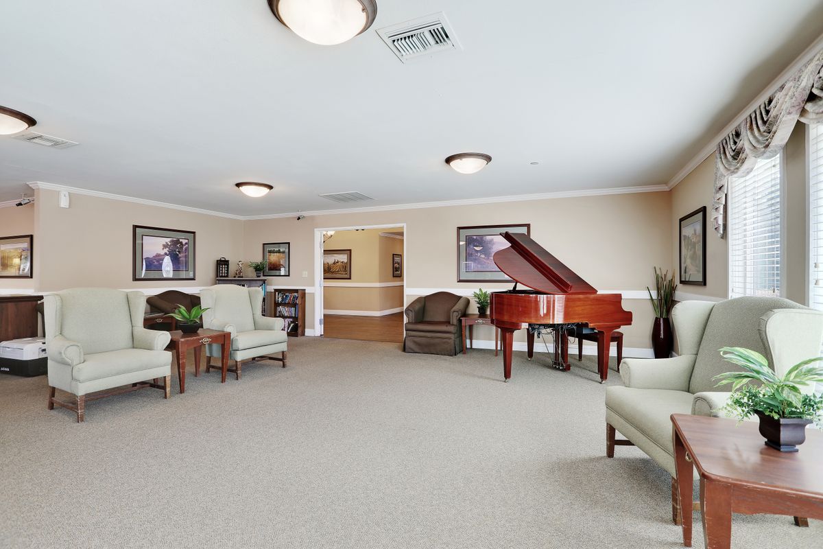 A spacious living room with a grand piano and comfortable seating area.