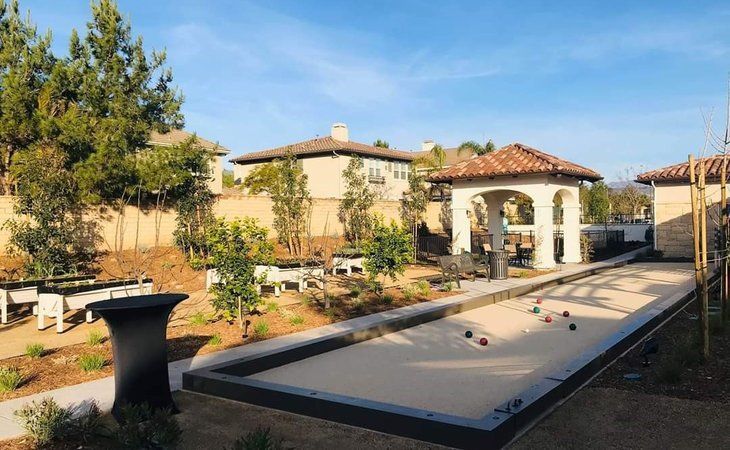 A beautifully landscaped backyard featuring a bocce court and a charming gazebo.
