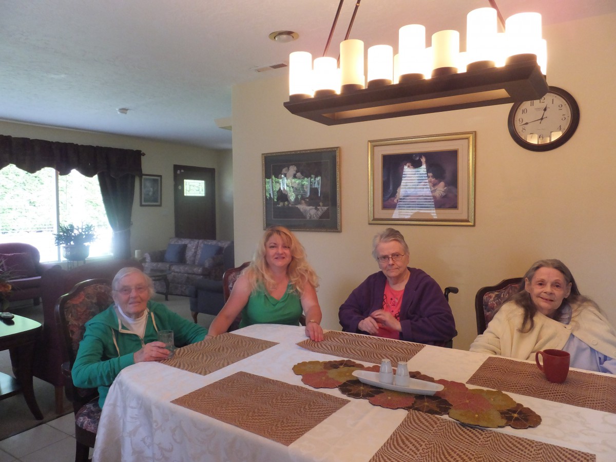 A group of people sitting around a dining table in a warmly lit room.