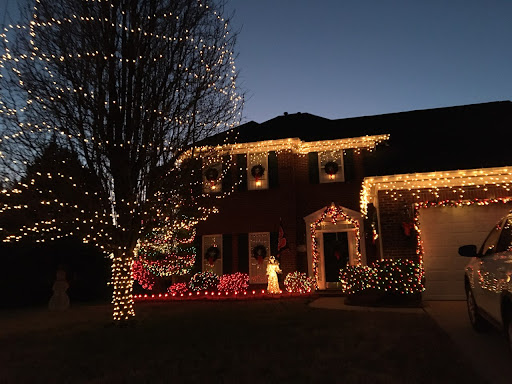 A beautifully decorated house glowing with Christmas lights during the evening.