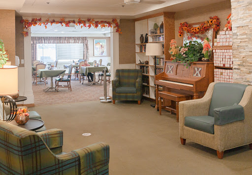 A cozy lounge area featuring comfortable seating, a piano, and decorative elements creating a welcoming atmosphere.