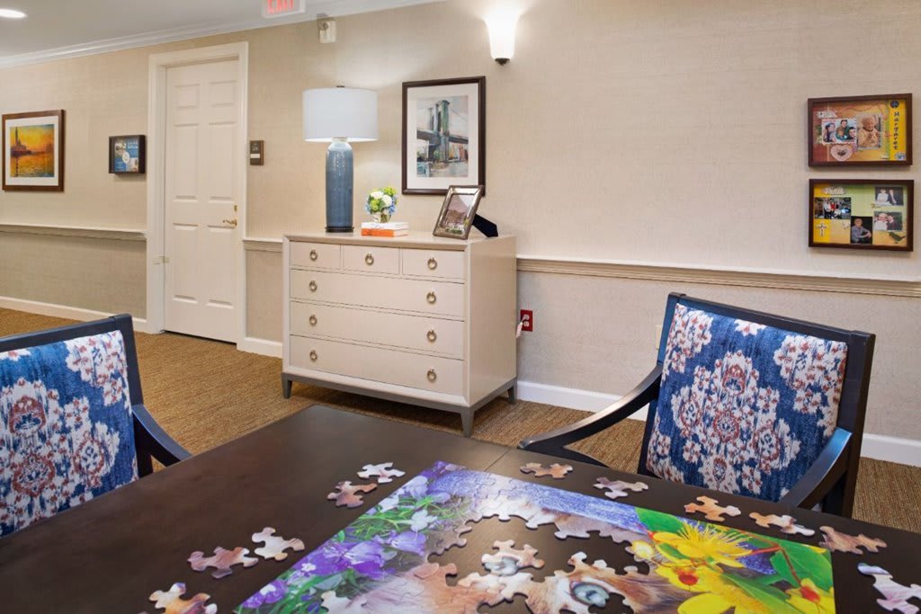A cozy living room with a table featuring a partially completed jigsaw puzzle and elegant decor.