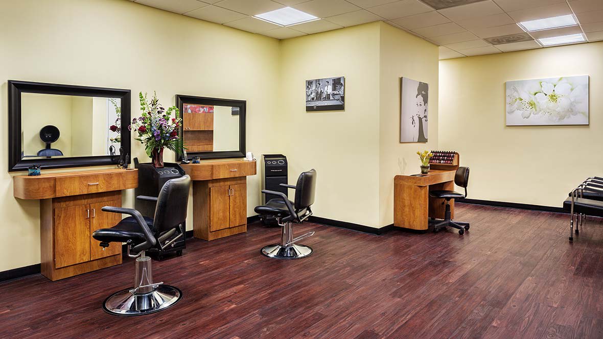 A neatly arranged hair salon interior with styling stations and chairs.