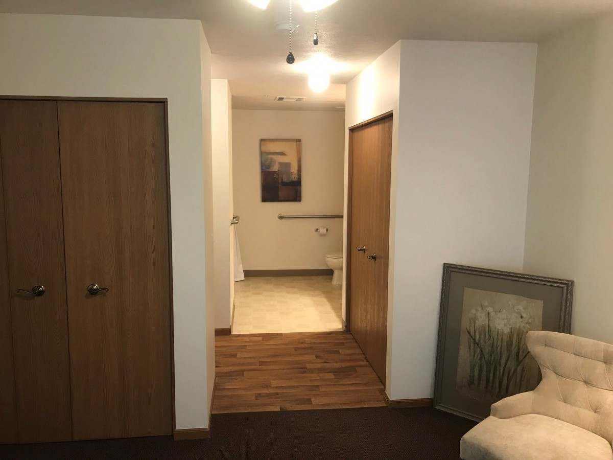 A cozy hallway featuring wooden doors and wall art under warm lighting.