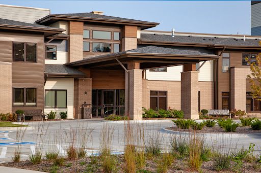 A modern architectural building with a welcoming entrance and landscaped surroundings.