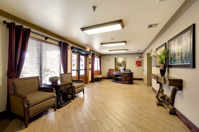 A spacious and well-lit lobby area with comfortable seating and wooden flooring.
