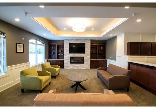 A modern living room with comfortable seating, a fireplace, and a mounted television.