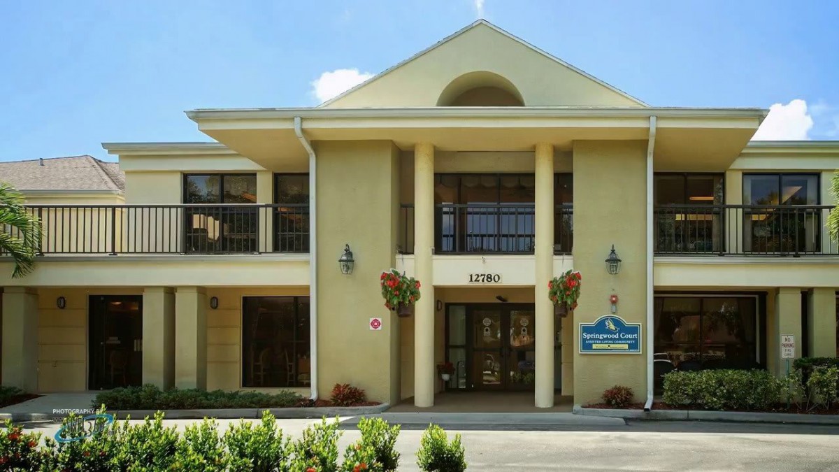 A hotel entrance featuring classical architecture with columns and a welcoming sign.