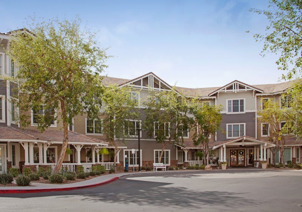 A charming residential building surrounded by trees on a sunny day.