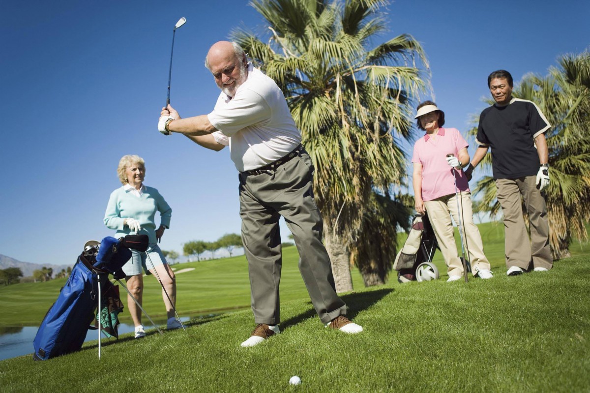 A group of seniors enjoying a sunny day on the golf course.