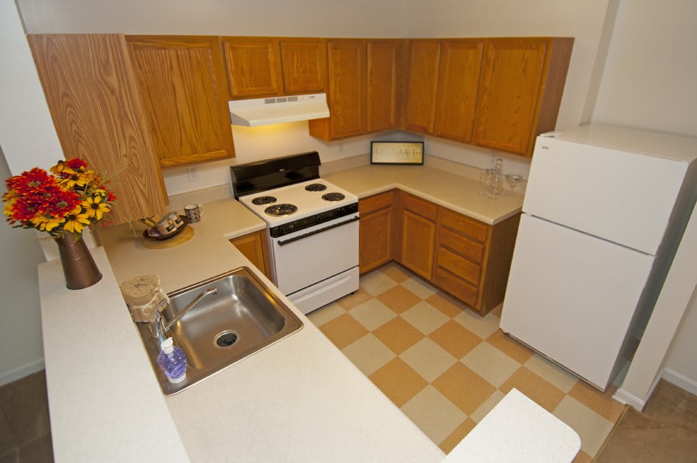 A compact kitchen with wooden cabinets and standard appliances.