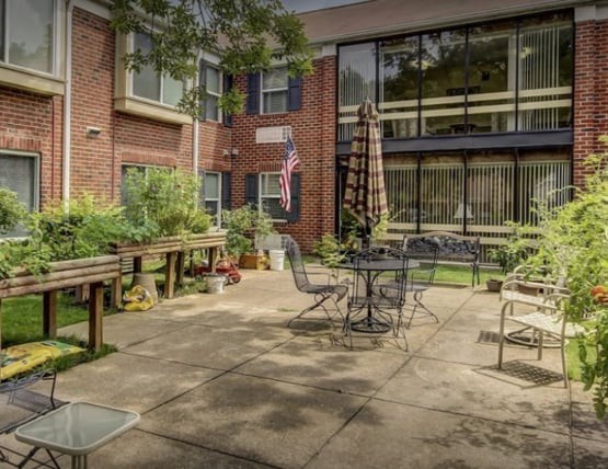 A cozy courtyard with outdoor seating and lush greenery.