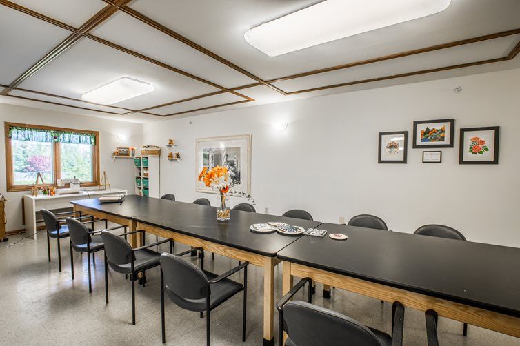 A modern conference room with a long table, surrounded by chairs, and bright lighting.