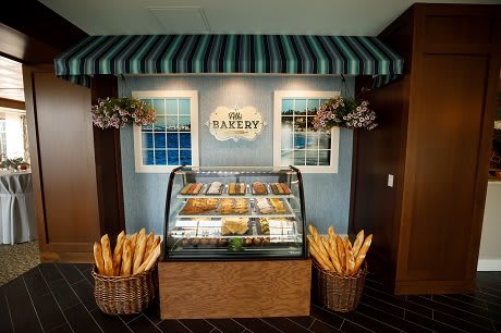 A cozy bakery display with a variety of pastries and baguettes in baskets.