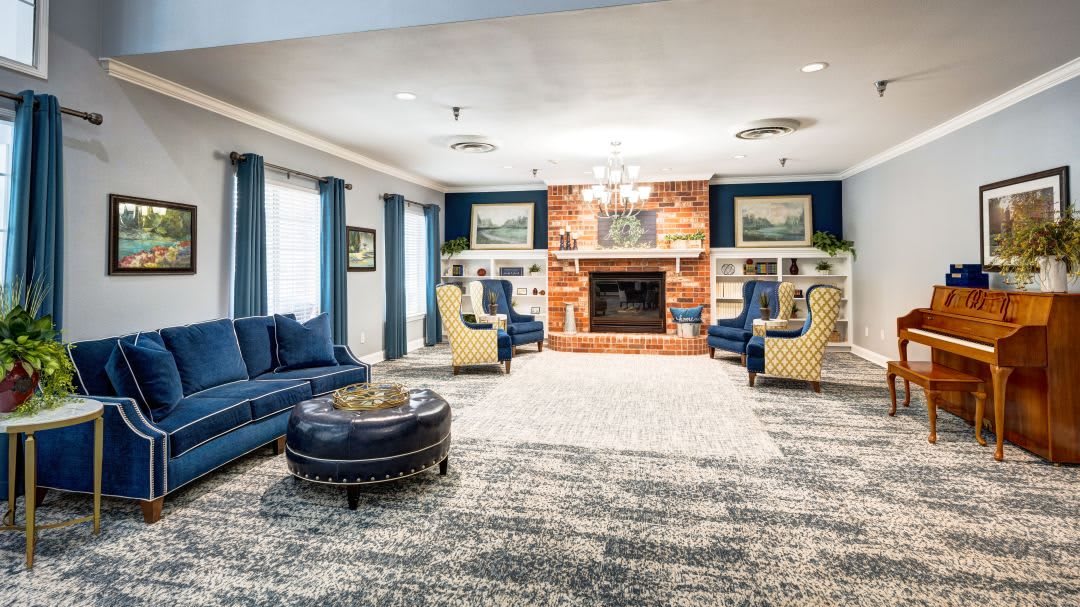 A cozy living room with elegant furniture, featuring a central fireplace and comfortable seating.