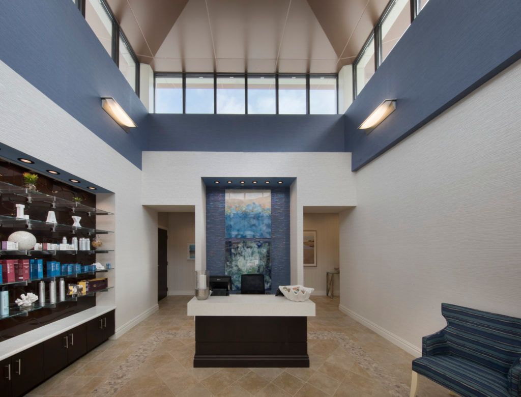 A modern lobby area with a reception desk, high ceilings, and stylish decor.