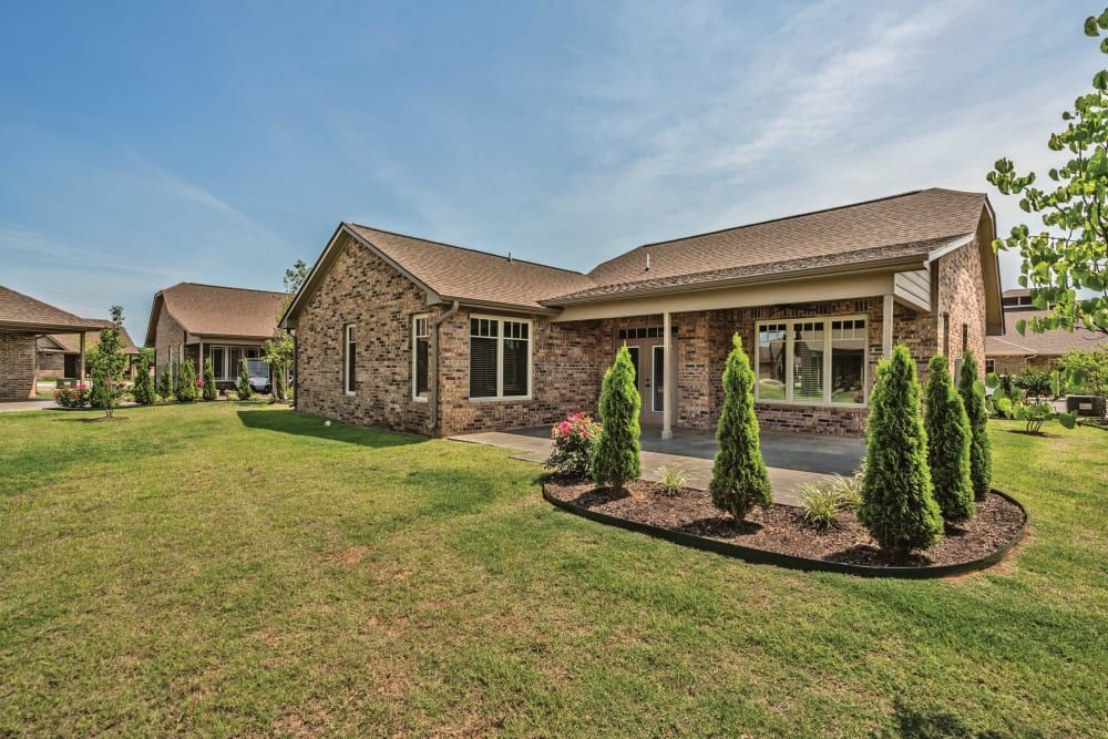 Beautiful brick house with well-maintained landscaping and a green lawn.