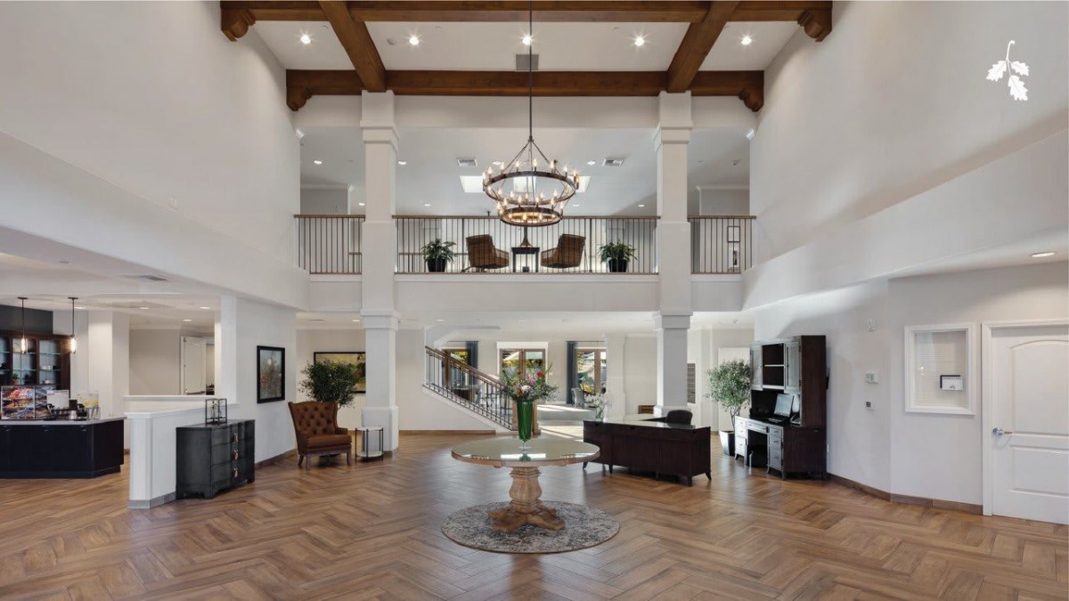 Spacious lobby with elegant decor and a central chandelier.