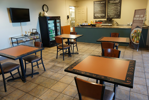 A cozy restaurant interior with tables and a food counter.