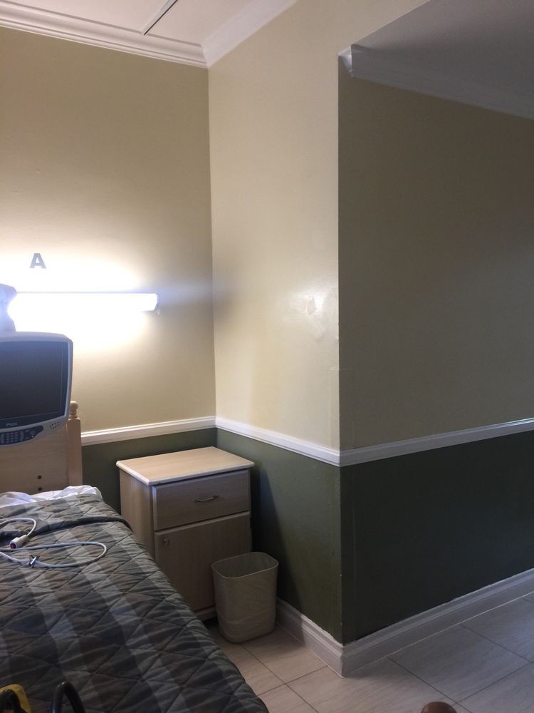 A cozy bedroom with a bedside lamp and dresser.