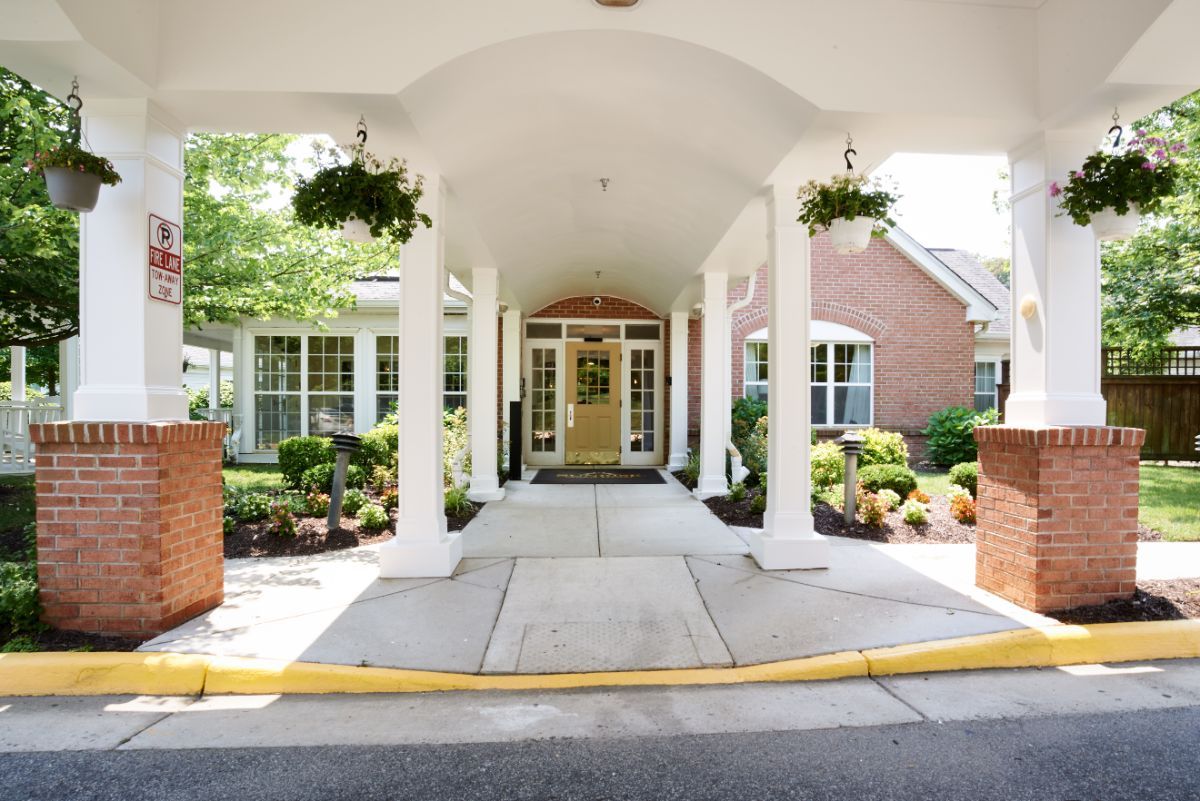 A welcoming entrance to a building with a covered walkway and well-maintained landscaping.