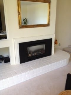 A modern fireplace setup with a large mirror and stylish decor.