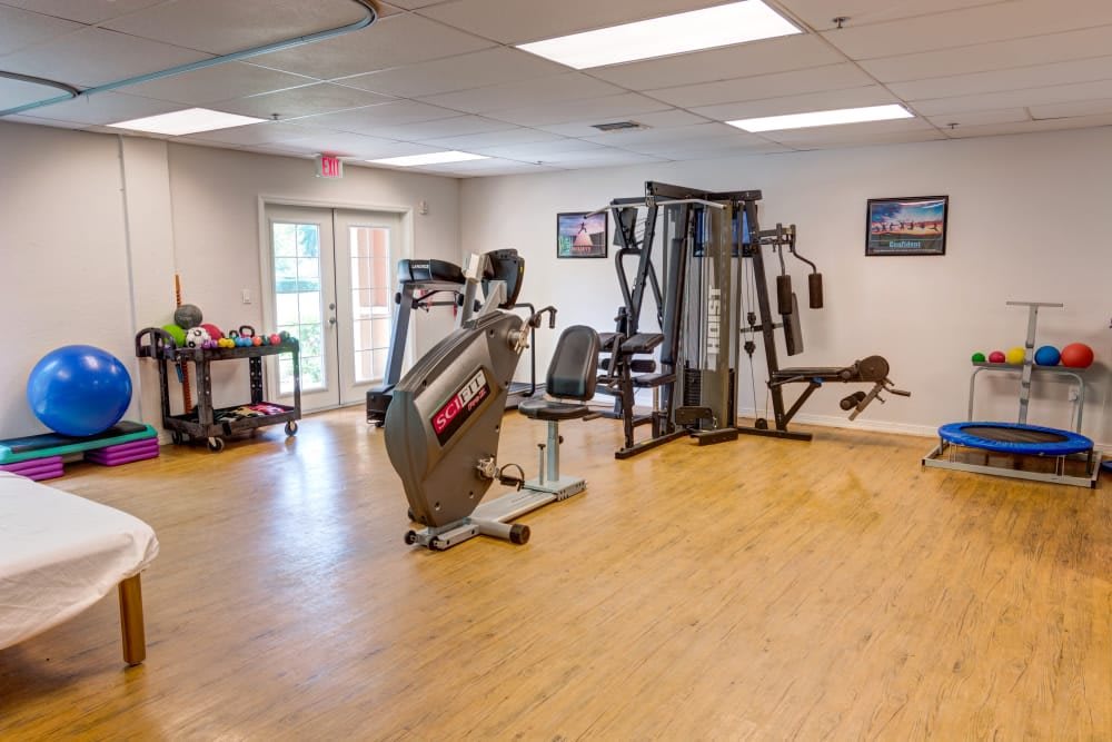 A small fitness center equipped with various exercise machines including an exercise bike and a multi-gym station.