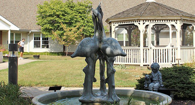 A decorative fountain featuring a bird sculpture in a garden setting.