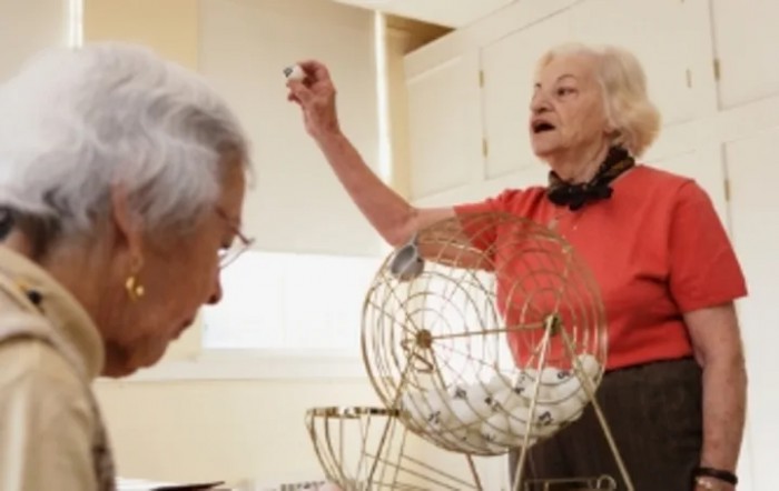 Two seniors enjoying a game of bingo.