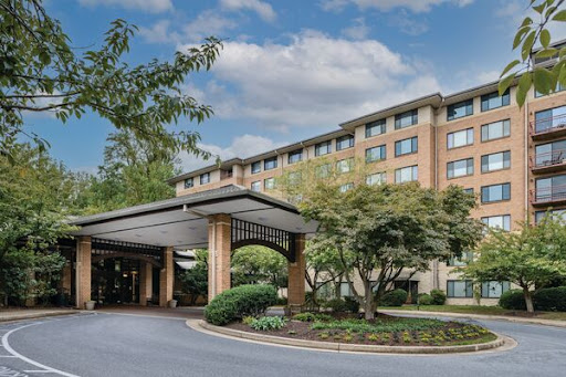 A welcoming view of a modern hotel entrance surrounded by lush landscaping.